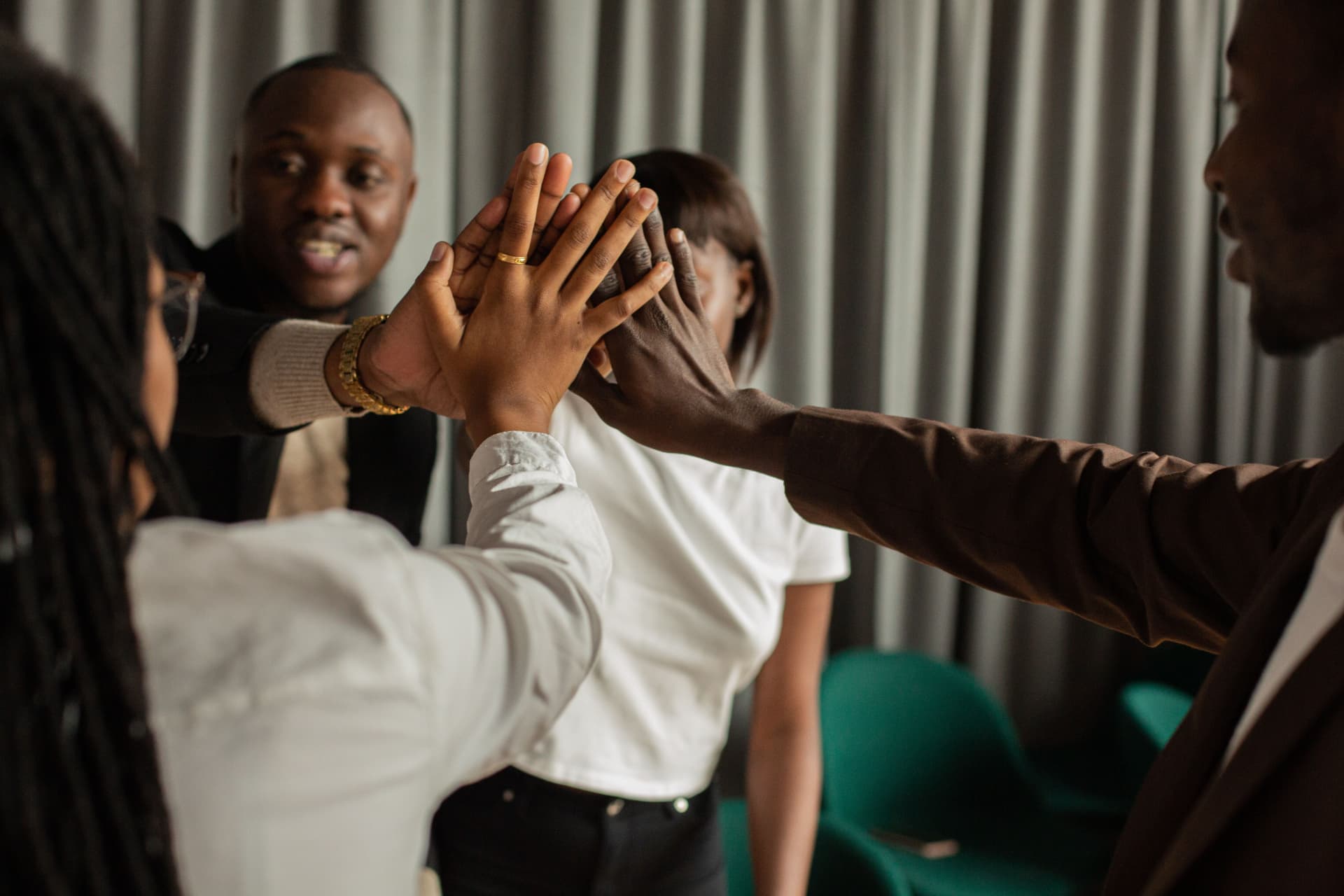 Black professionals joining hands in a supportive team high-five